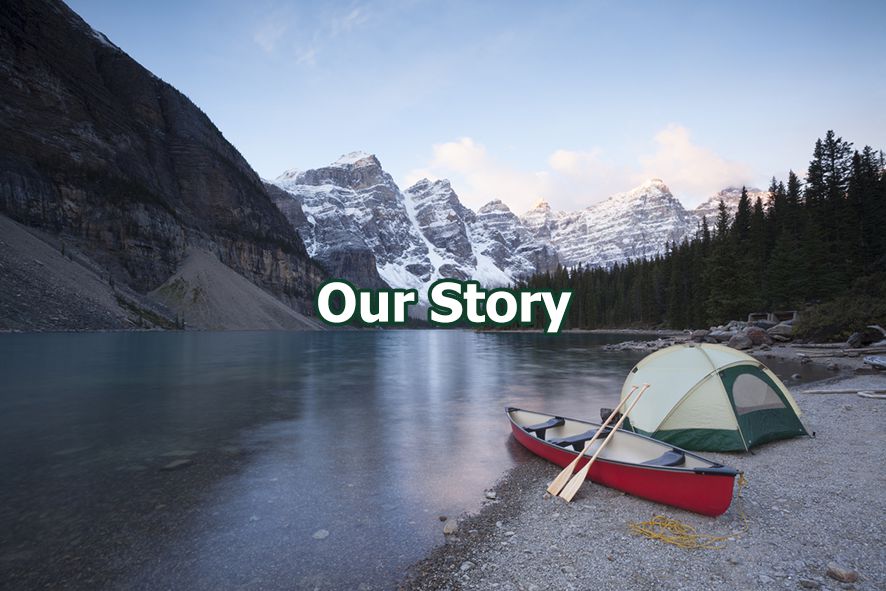 tent and canoe on beach of lake in front of mountains