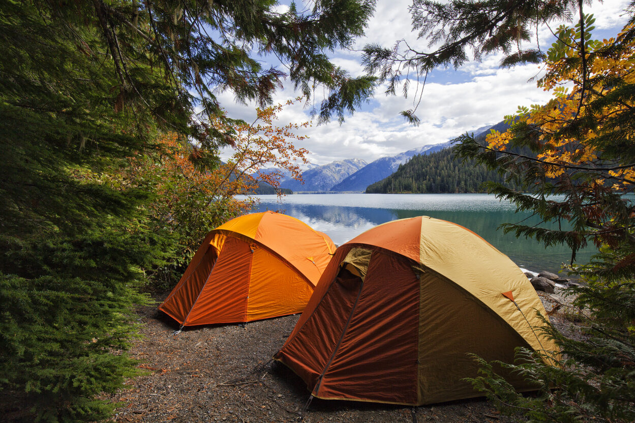 camping on the water in front of mountains