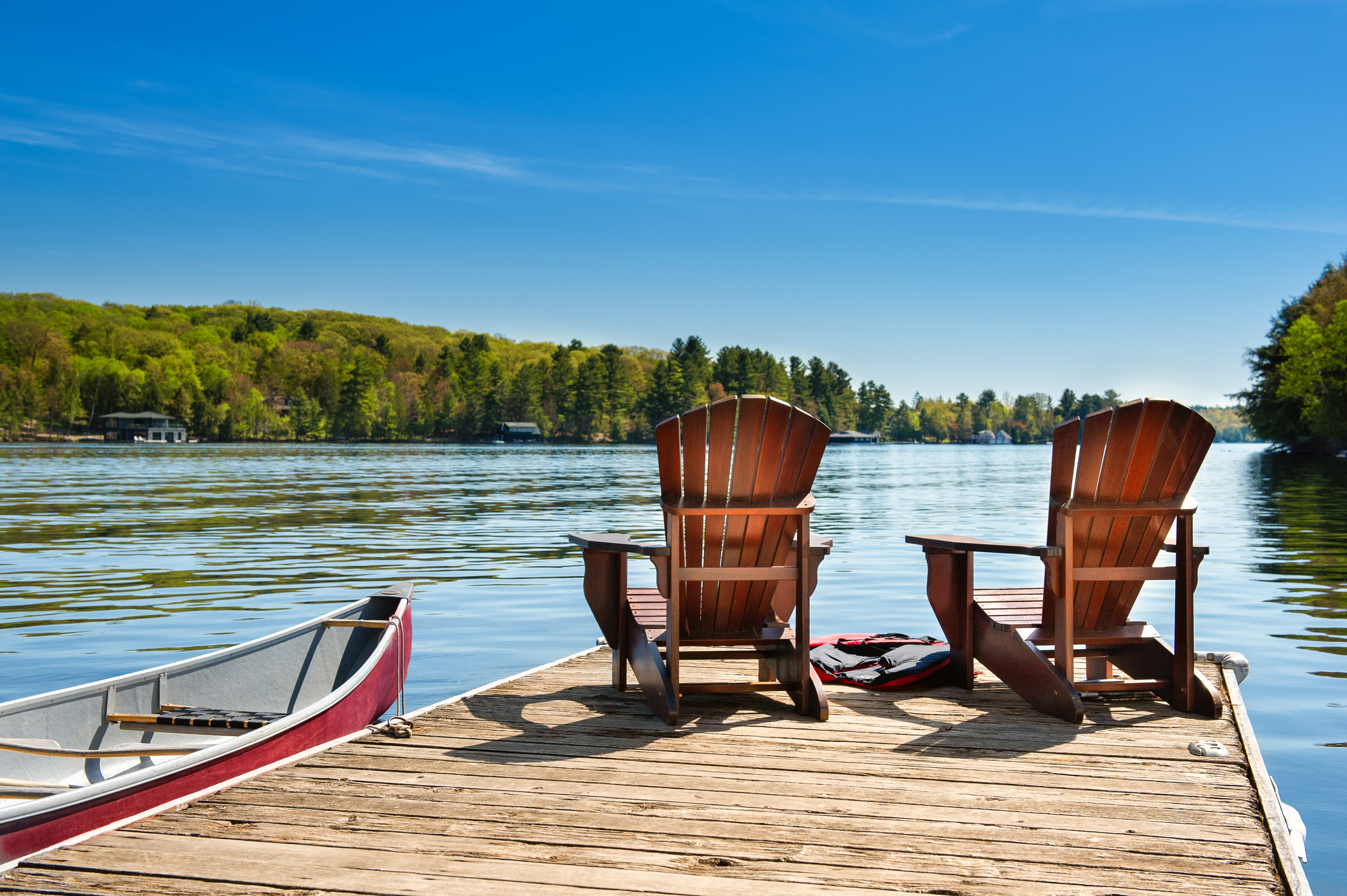 muskoka chairs on the dock on the water